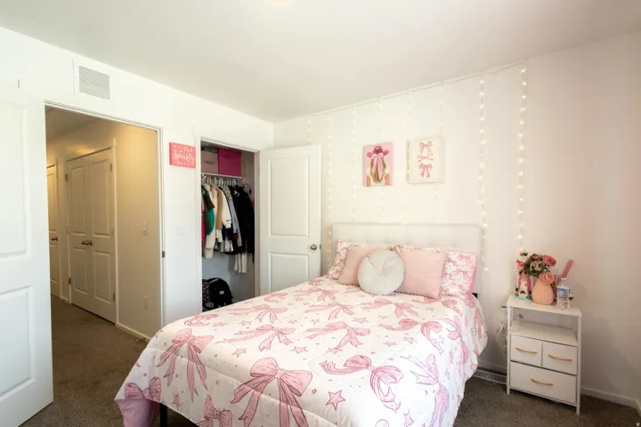 Bedroom featuring light-colored carpeting, a built-in closet with double doors, and a solid white interior door