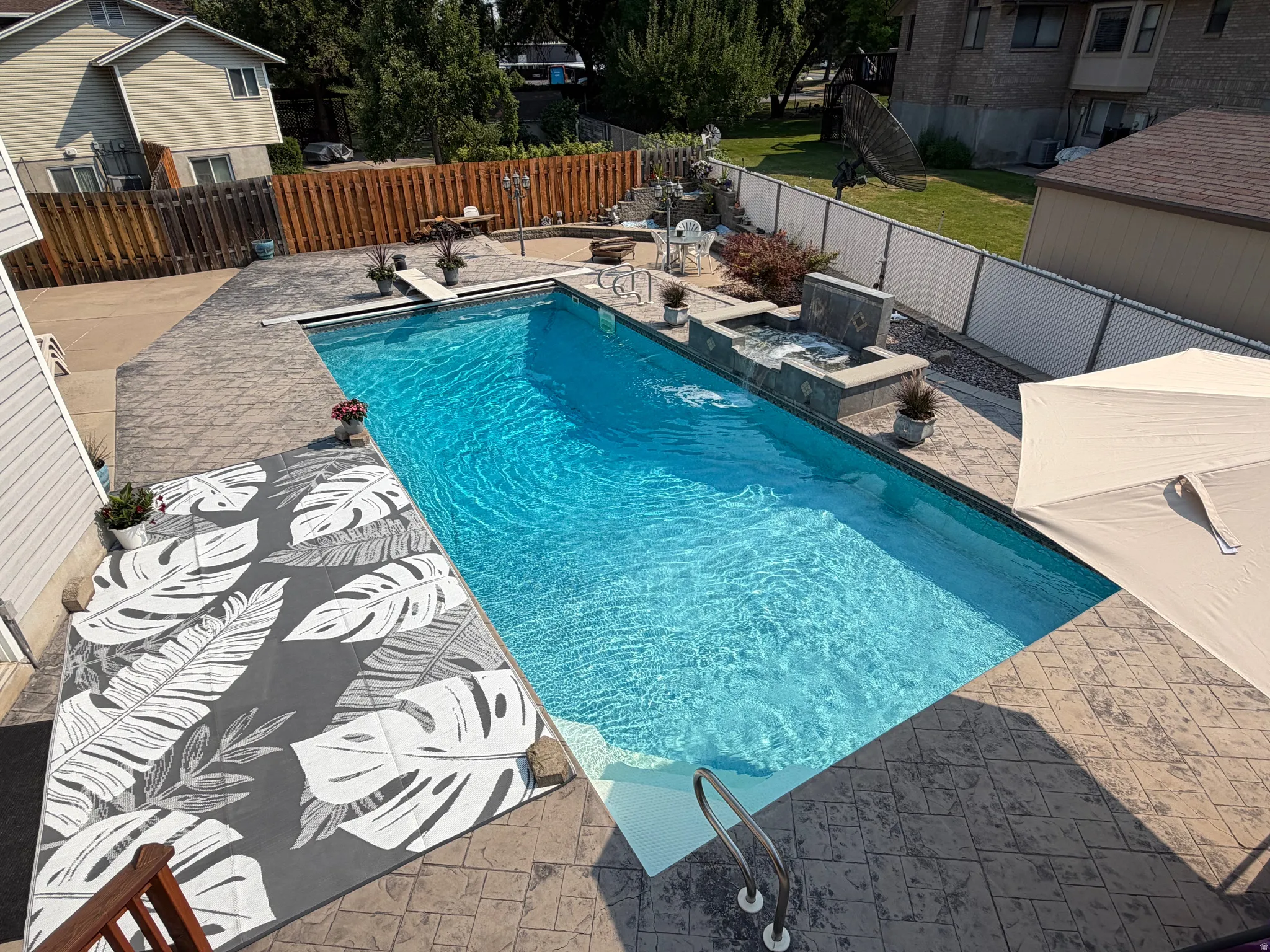 In-ground swimming pool with stamped concrete surround