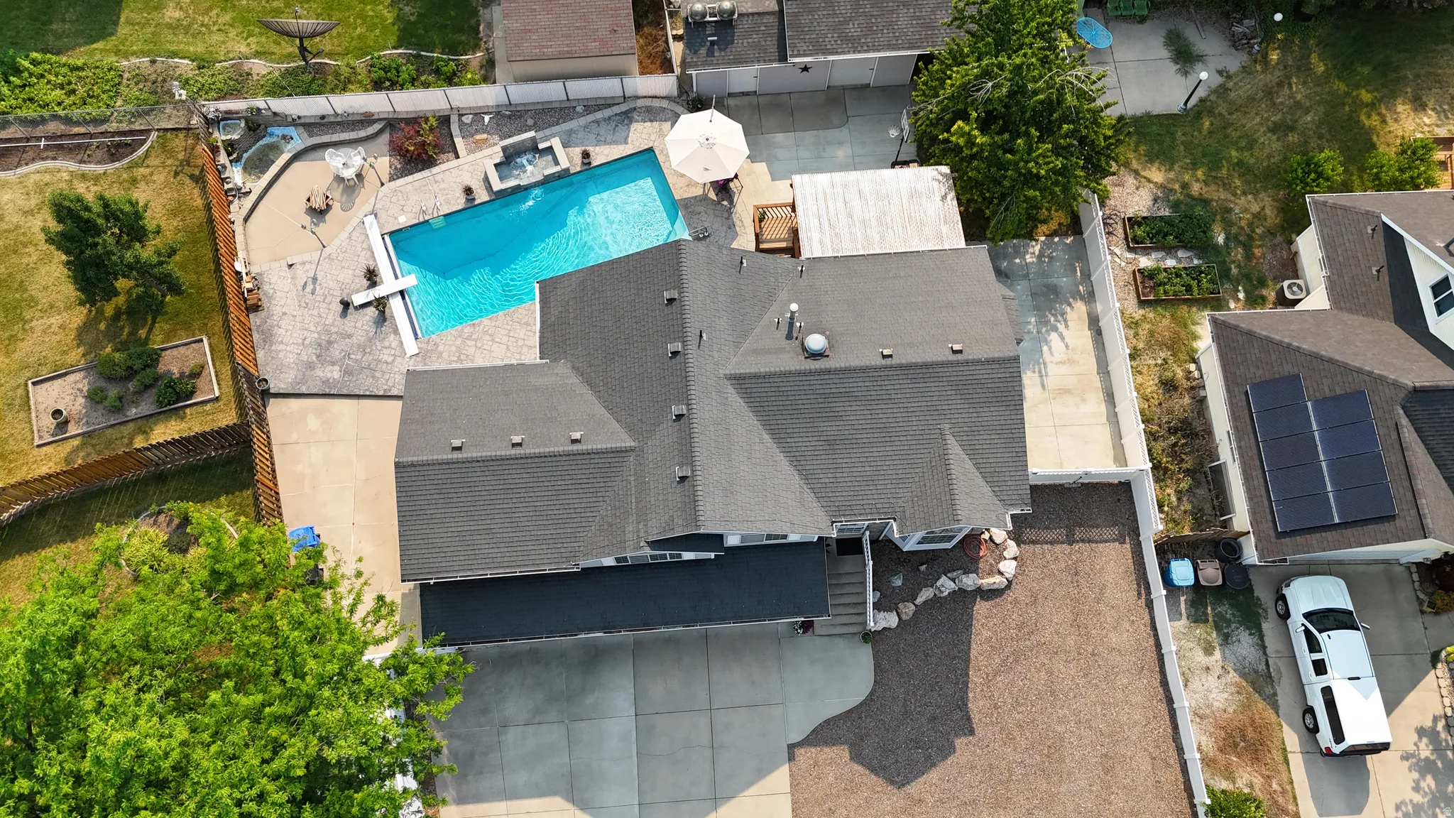 Rear exterior featuring a swimming pool, integrated spa, and expansive concrete patio