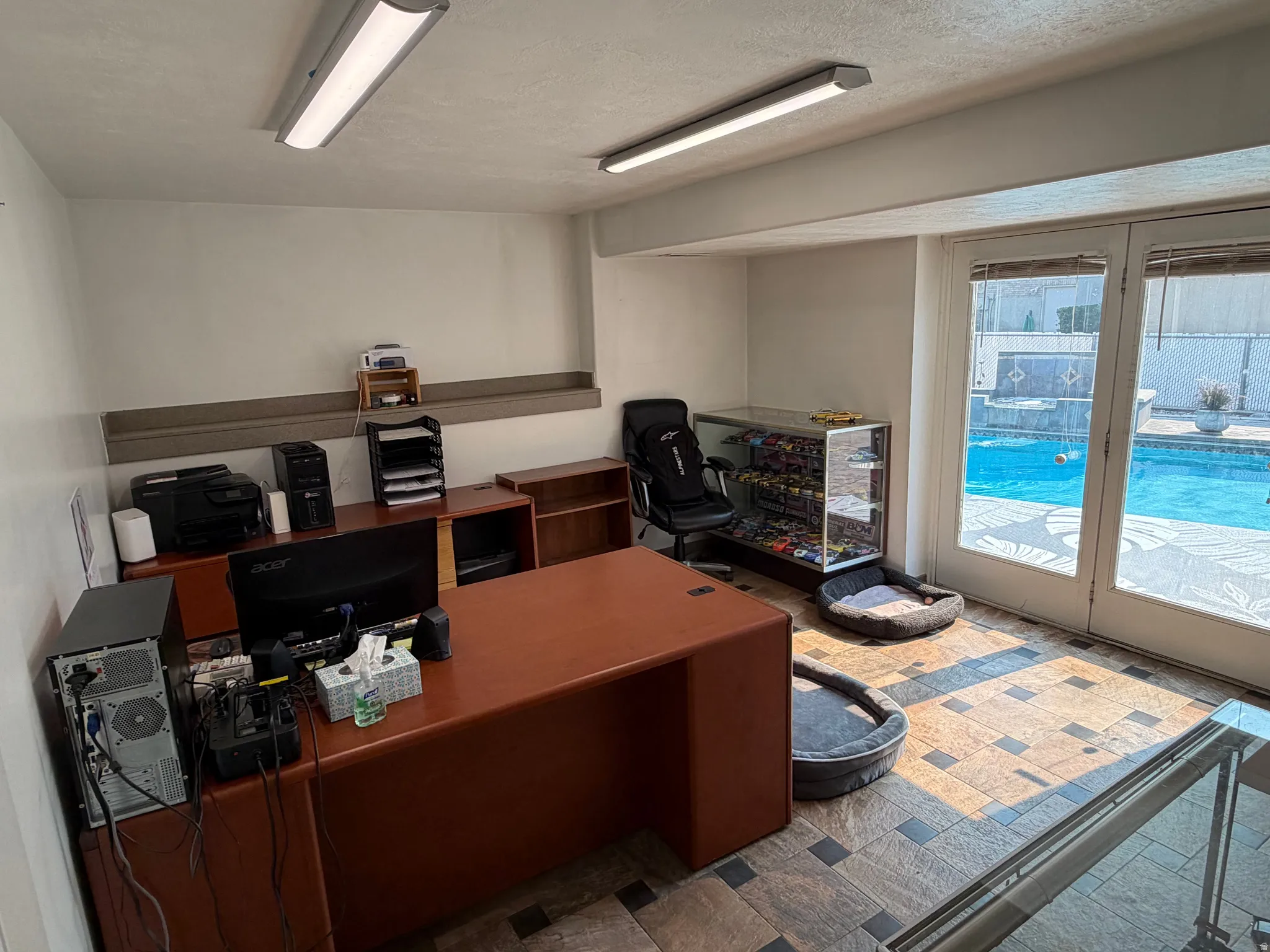 Room featuring tiled flooring, track lighting, and a built-in display case