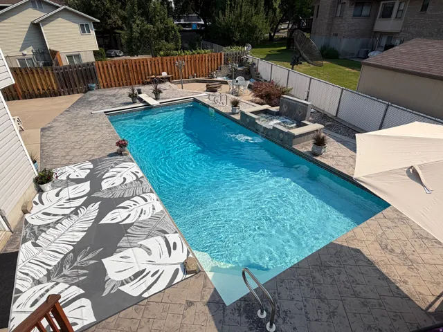 In-ground swimming pool with stamped concrete surround