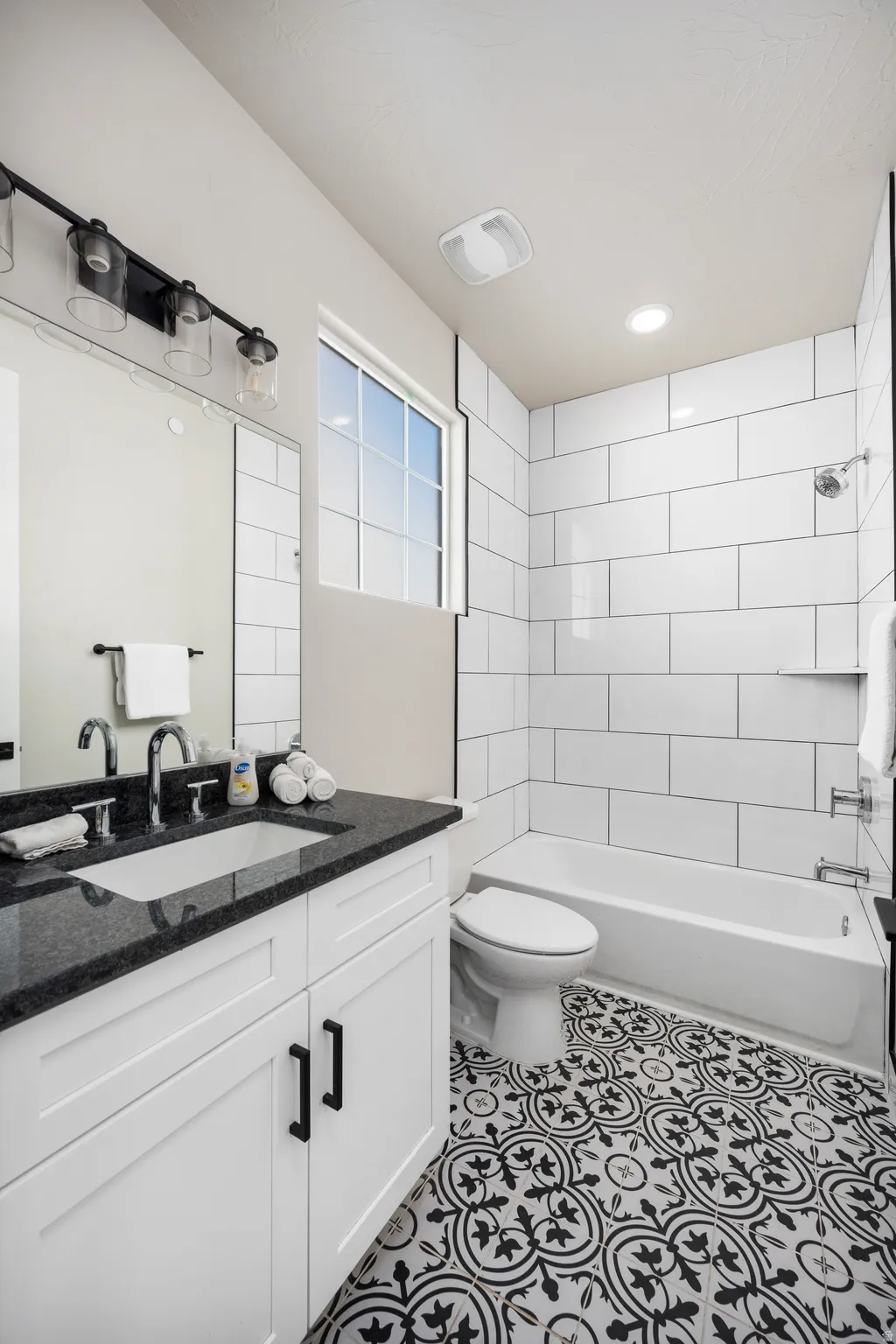 Bathroom featuring decorative black and white floor tiling