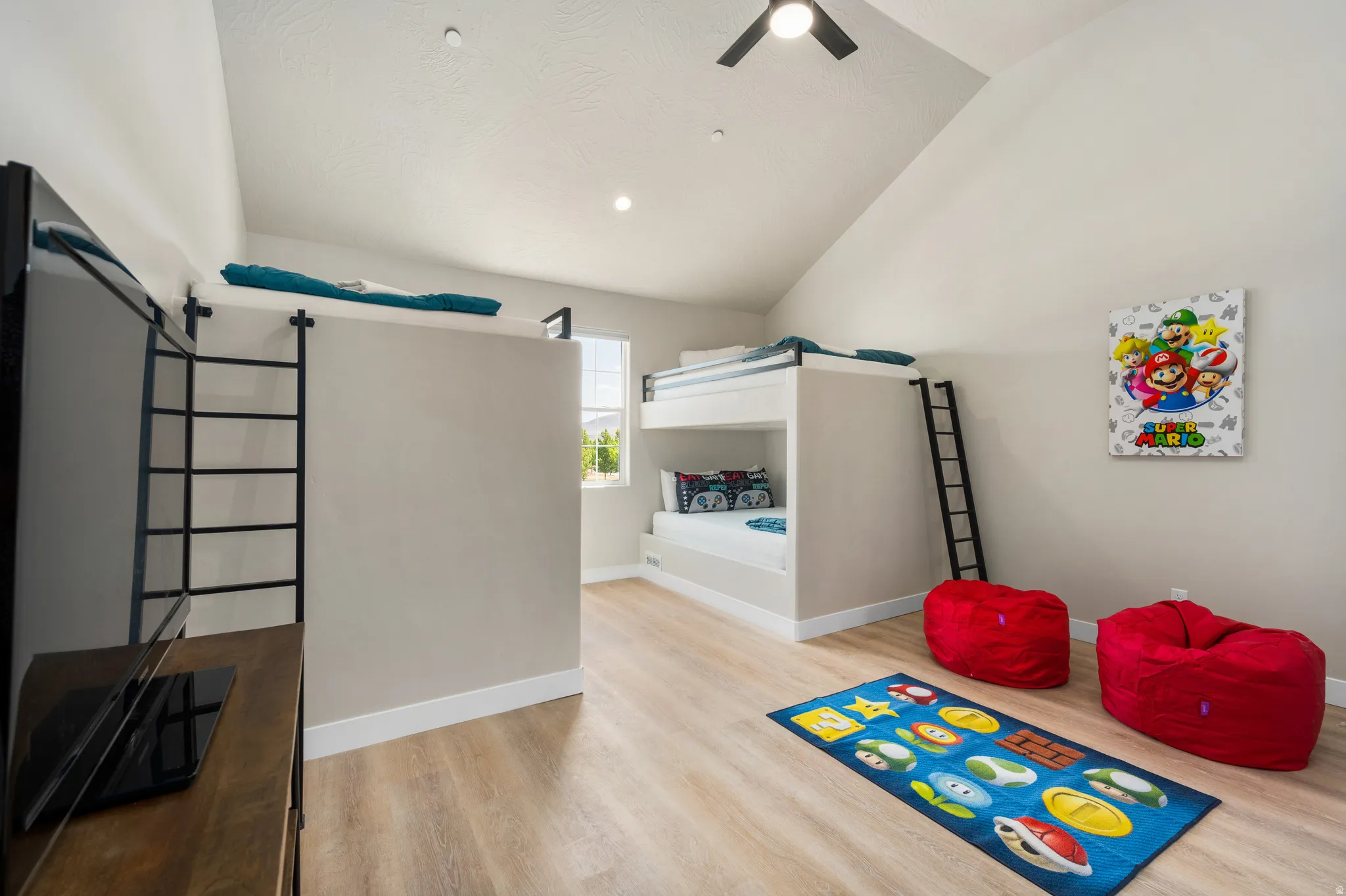 Vaulted ceiling bedroom with light wood-finish flooring