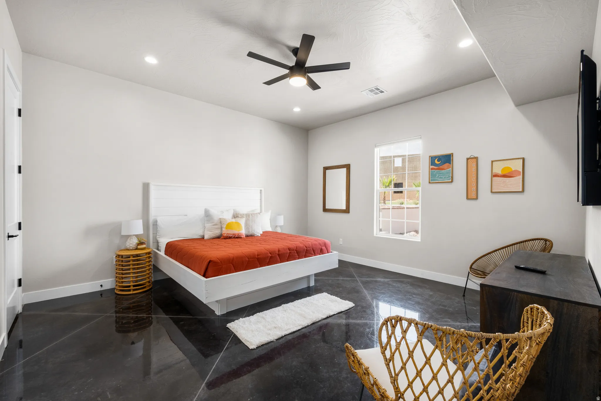 Spacious room featuring polished concrete flooring, recessed lighting, a ceiling fan, a window with exterior views, and a solid core door