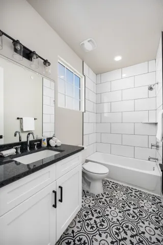 Bathroom featuring decorative black and white floor tiling