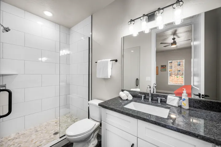 Bathroom featuring a glass-enclosed shower with subway tile surround and pebble tile flooring