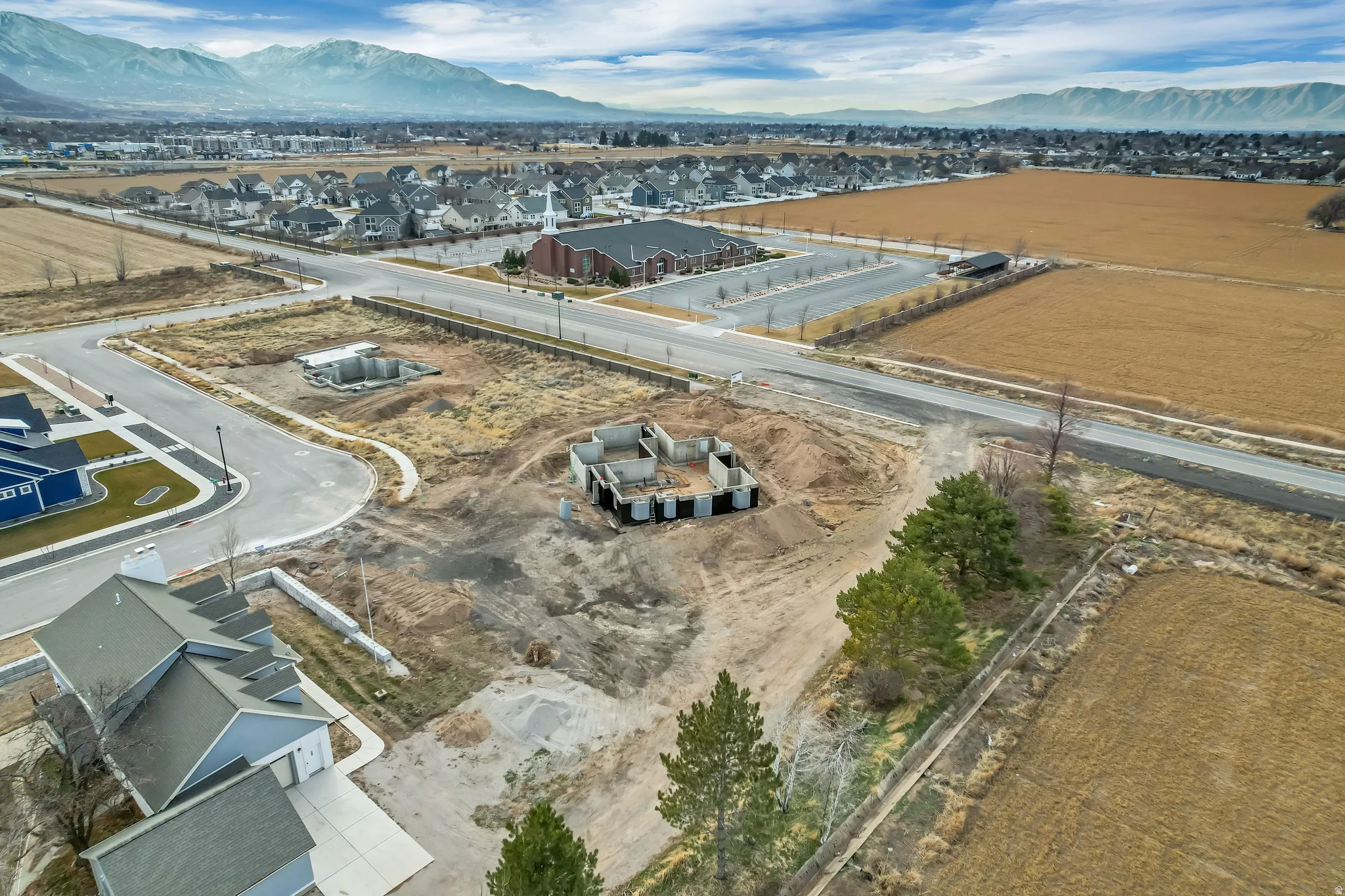 Expansive land parcel featuring established roads, visible mountain backdrops, and active construction sites