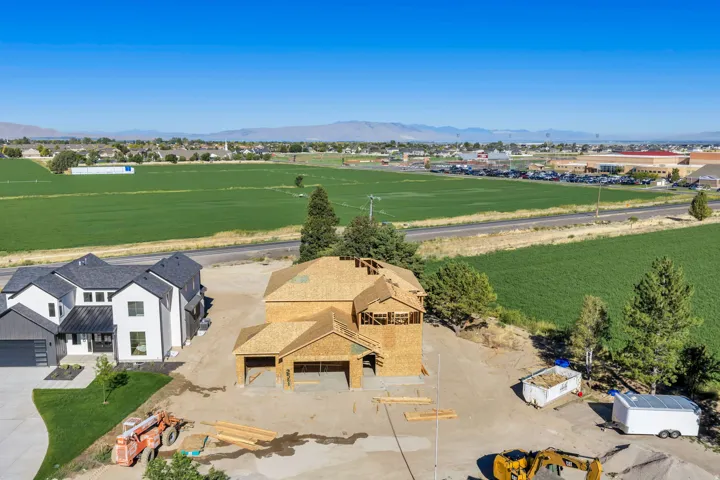 Framed two-story construction with an attached garage, situated on a lot with an adjacent completed home