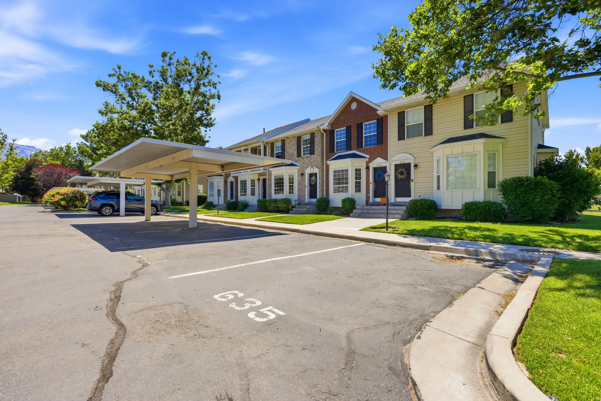Townhome exterior featuring multi-toned siding, bay windows, and individual front entrances