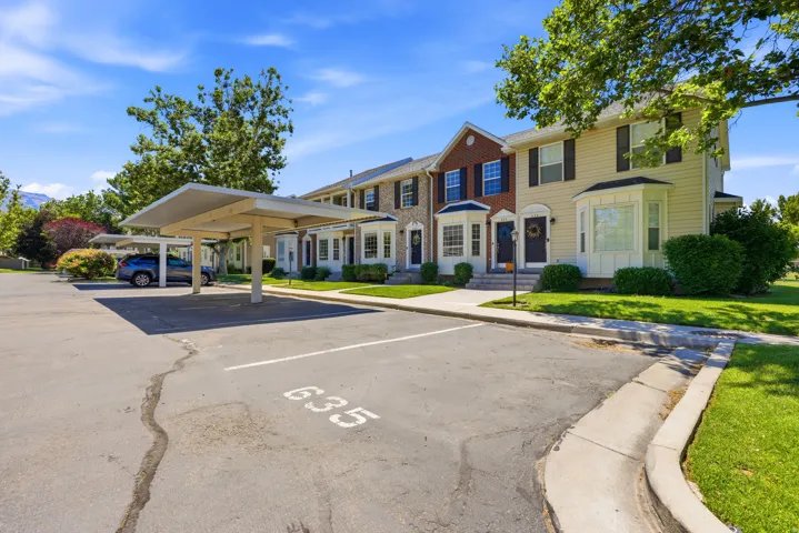 Townhome exterior featuring multi-toned siding, bay windows, and individual front entrances