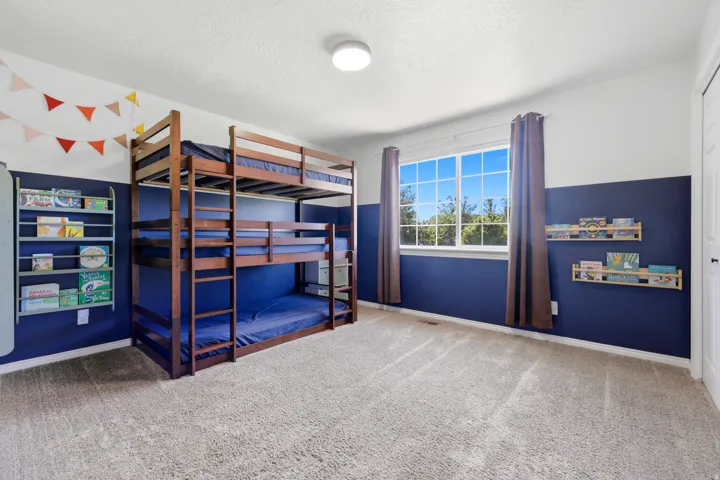 Room featuring a large window with white framing, neutral-toned carpeting, and a two-tone painted wall