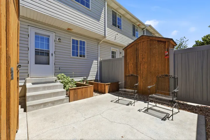 Private patio space featuring a concrete slab and wood-paneled privacy fencing