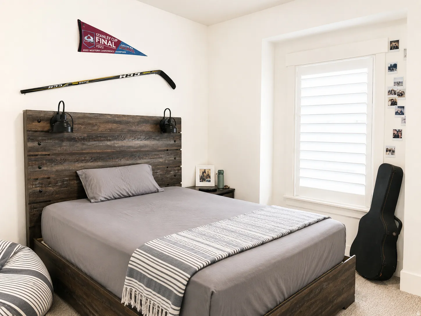 Bedroom featuring a wood-finish bed frame with an integrated headboard and wall sconces