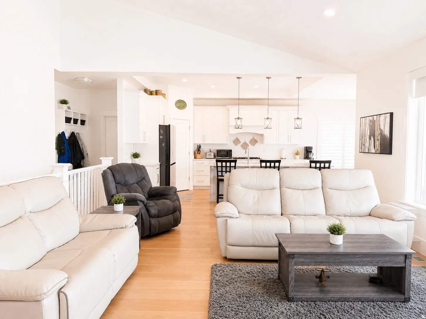 Vaulted ceilings accent an open-concept living area with wood-finish flooring