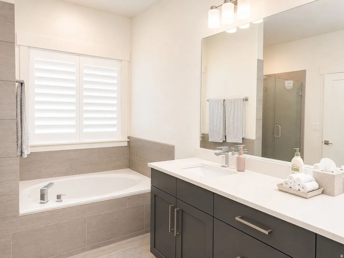Integrated soaking tub with tiled surround and plantation shutters