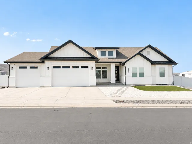 Modern farmhouse exterior with a white board and batten facade and dark trim accents
