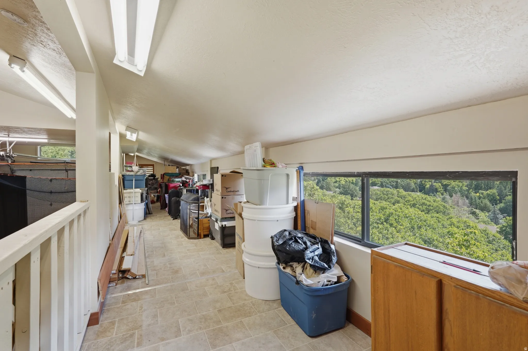 RV Garage Upper-level hallway featuring sloped ceilings, and windows