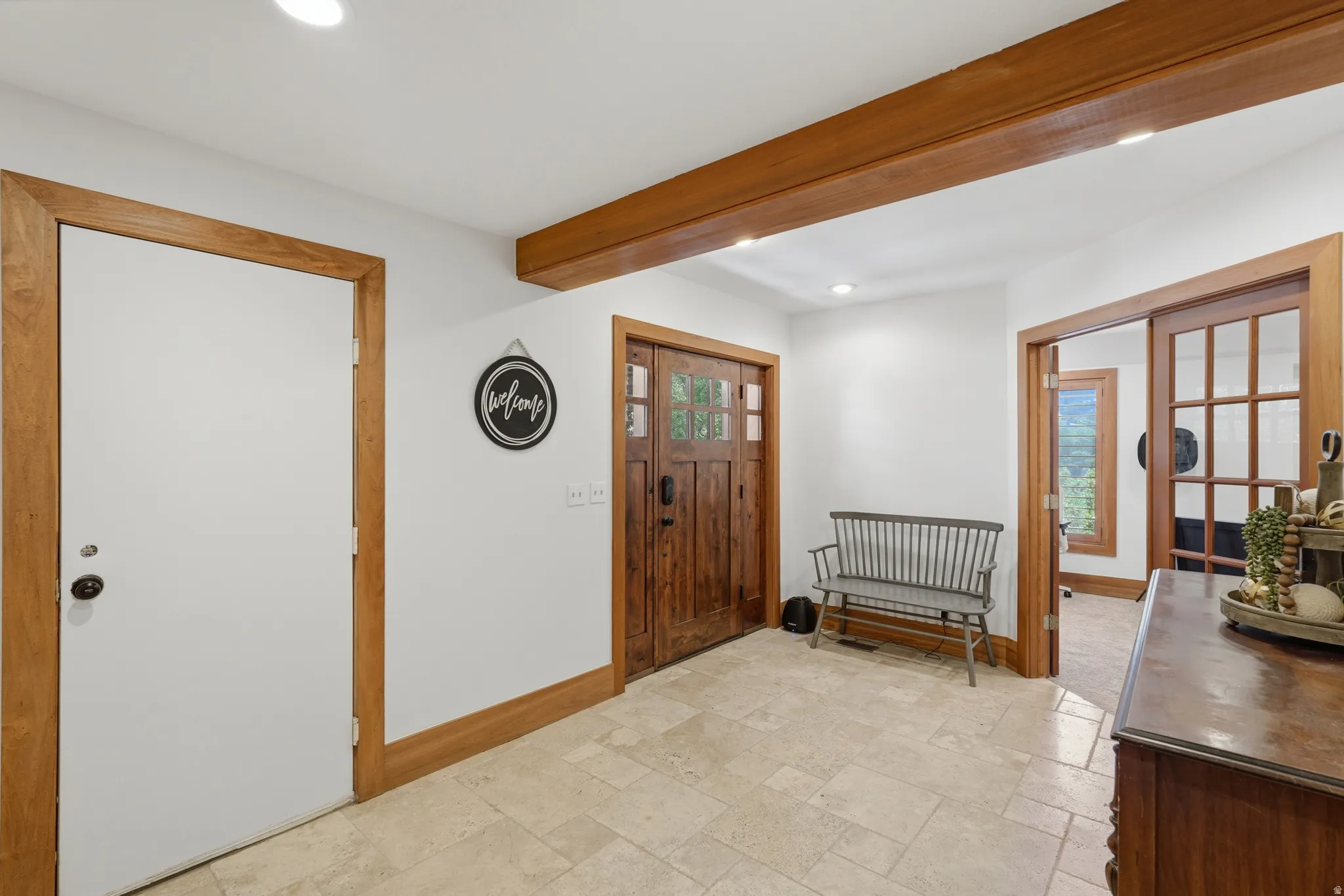 Entryway featuring light-toned tile flooring, exposed wood beams, and recessed lighting