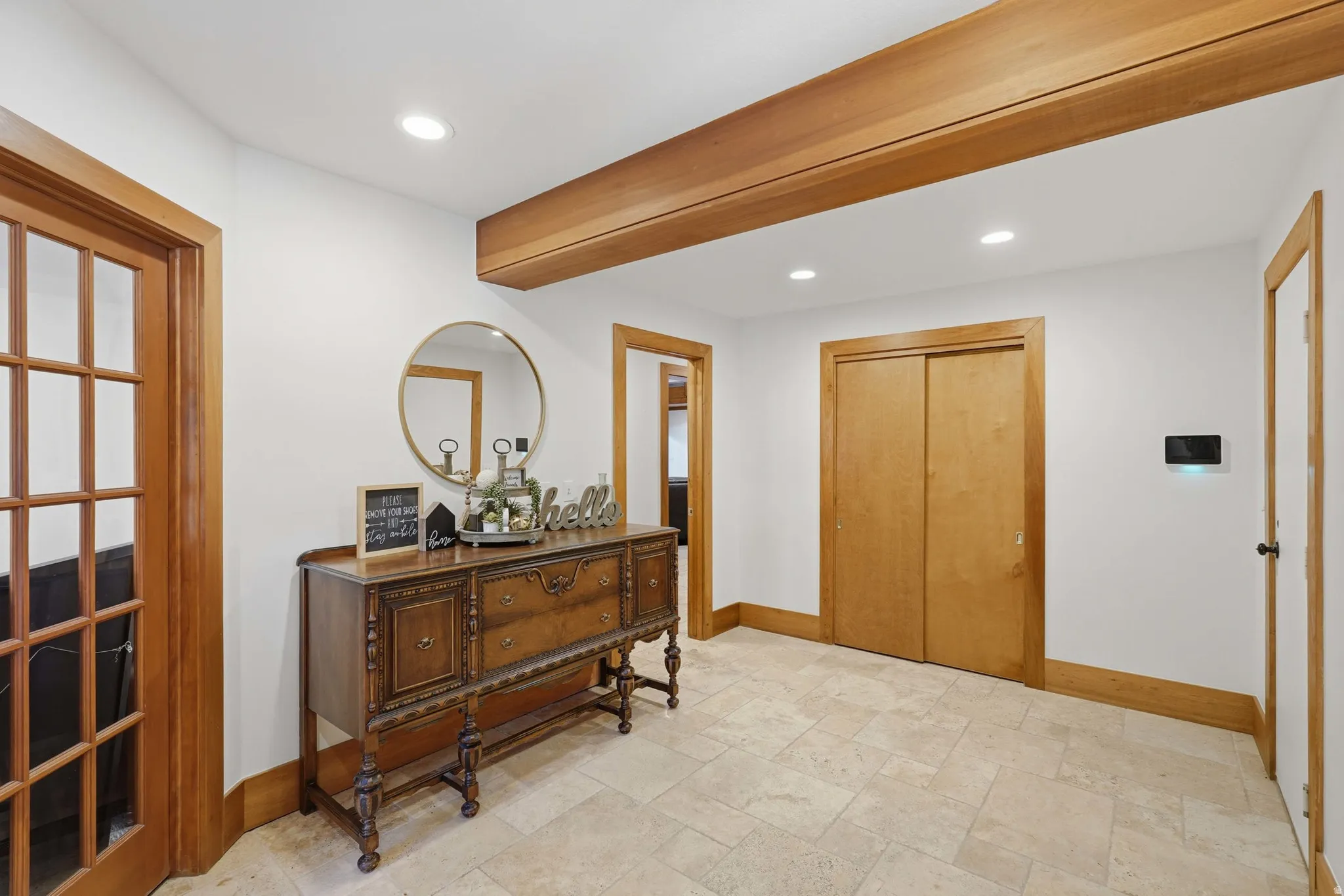 Entryway featuring tile flooring, recessed lighting, wood-finish trim, a wood-finish ceiling beam, and a paneled wood-finish door