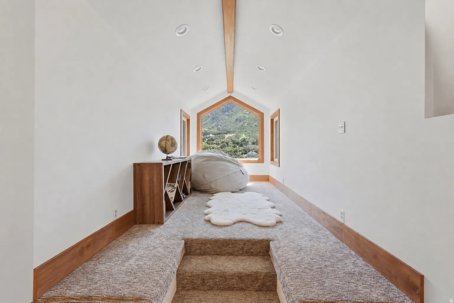 Vaulted sitting area in primary suite,  ceiling with exposed wood beam and recessed lighting