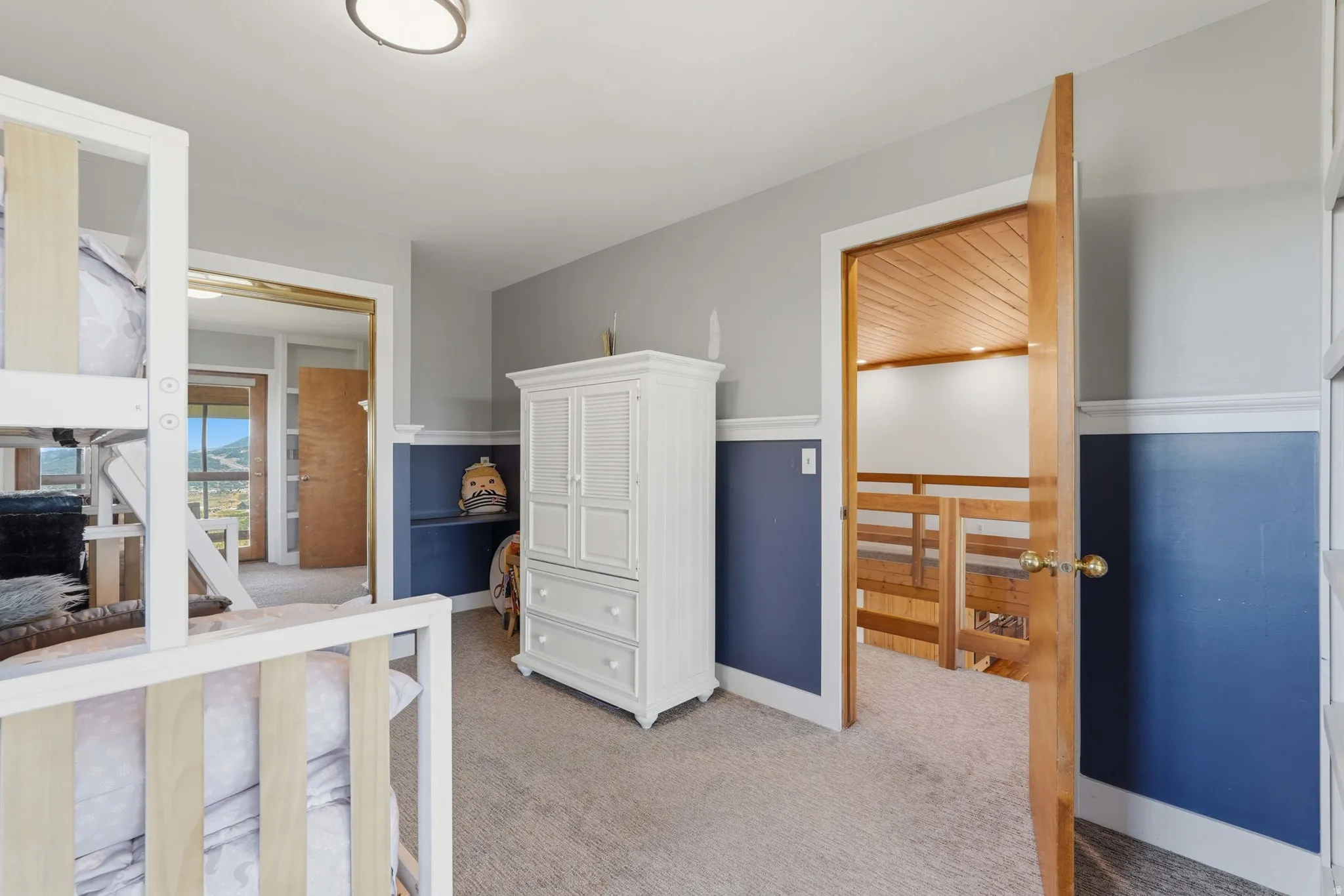 Carpeted room featuring a neutral color palette with blue wainscoting and white trim