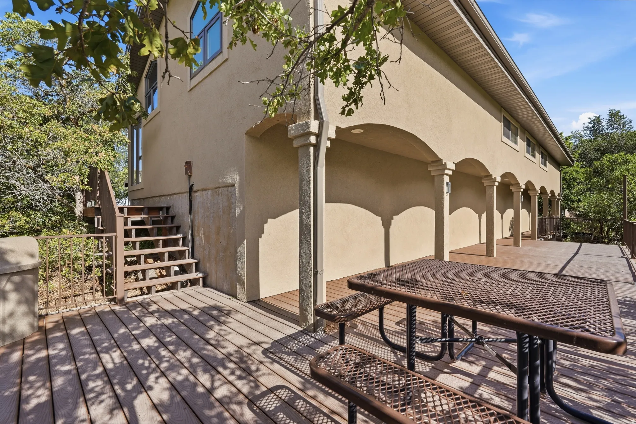 Expansive outdoor decking east of the pool area, with composite wood-finish boards