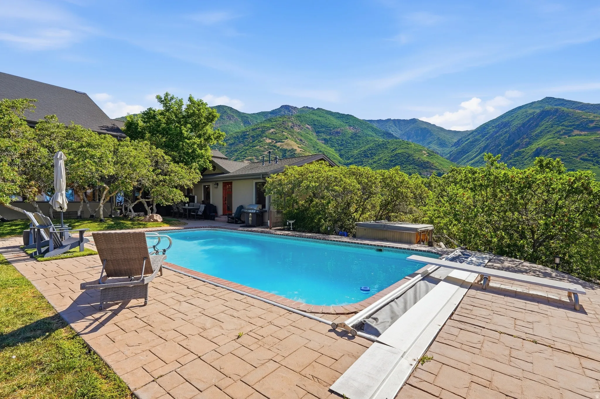 Expansive outdoor swimming pool featuring a textured paver surround