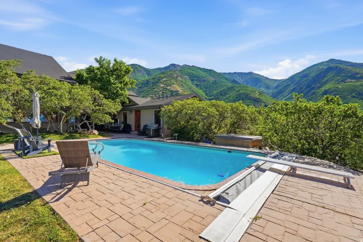 Expansive outdoor swimming pool featuring a textured paver surround
