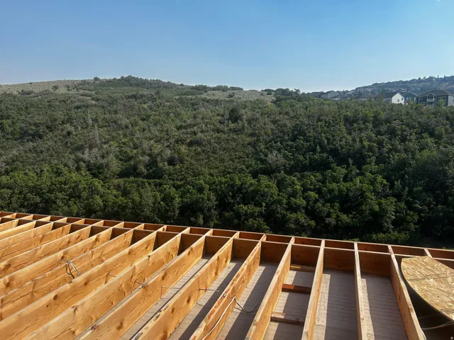 Framed roof decking with a serene, expansive green landscape backdrop