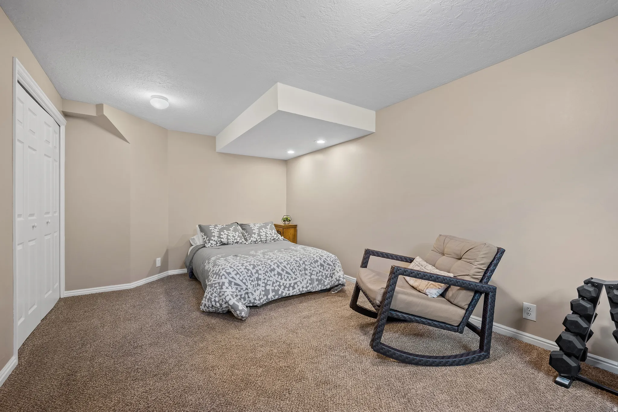 Carpeted bedroom featuring neutral-toned walls, white trim, a bi-fold closet door, and recessed lighting