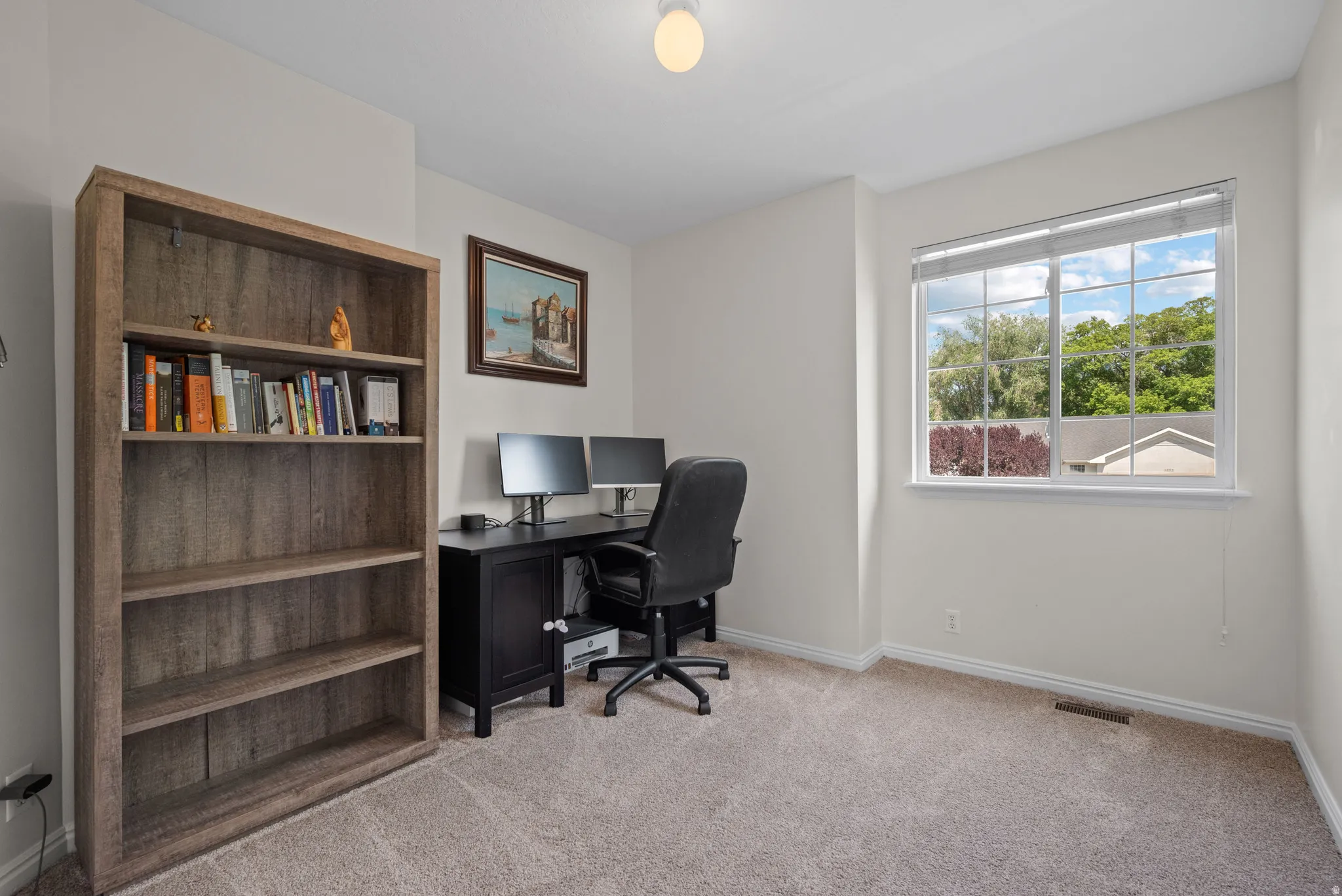 Spacious room featuring a large window, neutral paint, and carpeted flooring