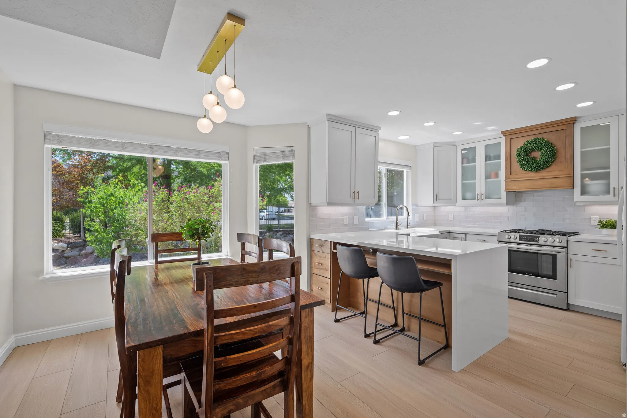 Modern kitchen and dining area featuring light wood-finish flooring