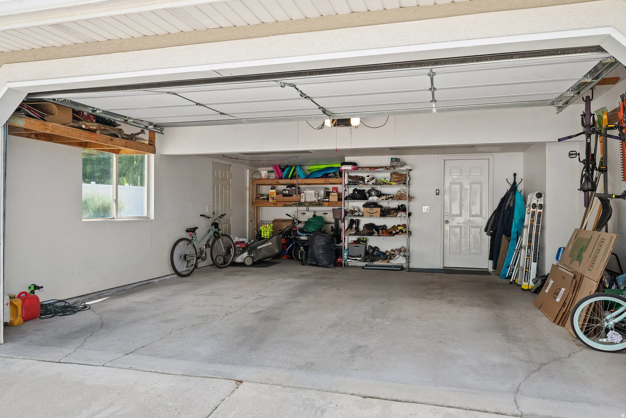 Spacious garage featuring a concrete floor, white interior walls, and an overhead garage door mechanism