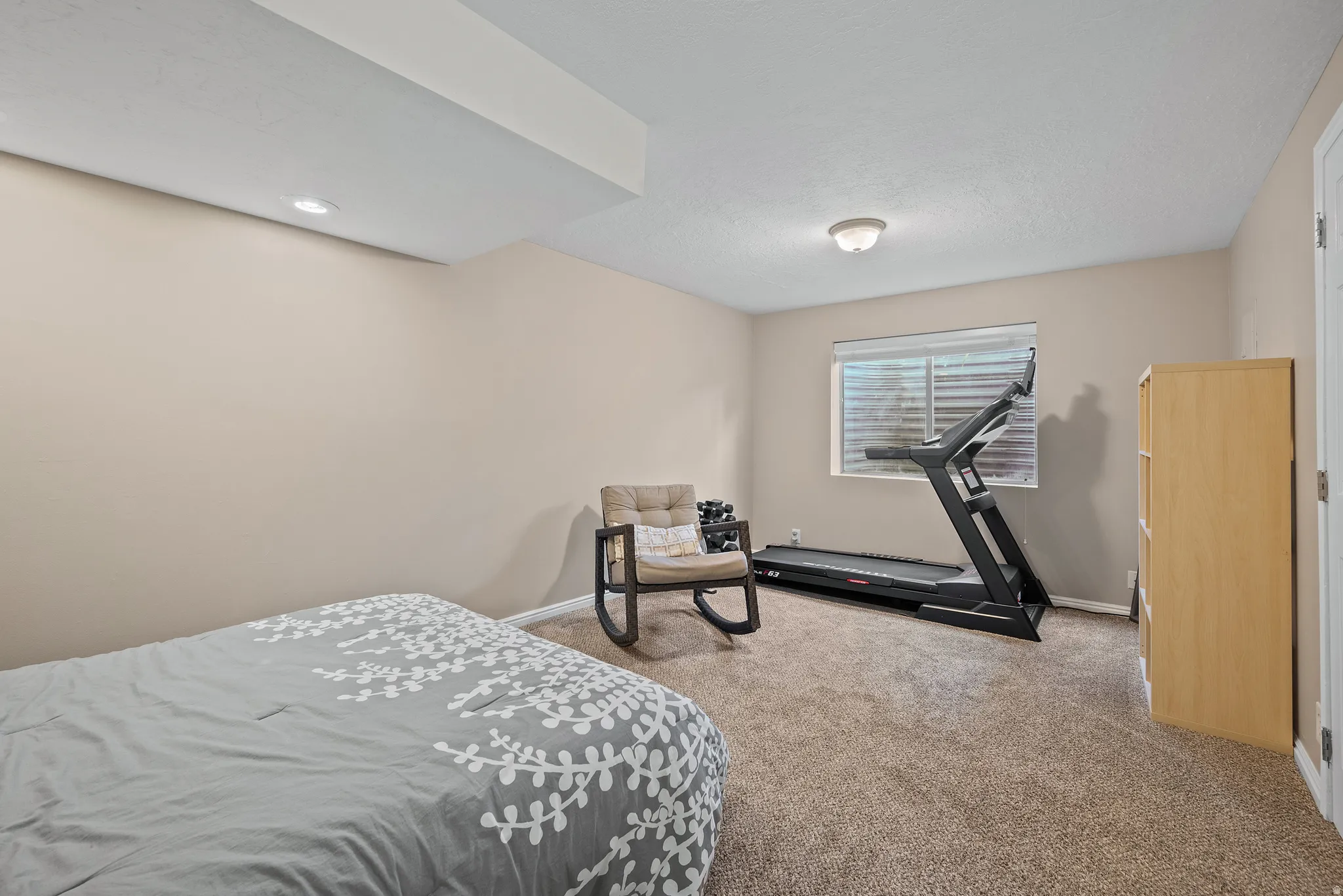 Carpeted room with a ceiling light fixture, recessed lighting, and a window with blinds