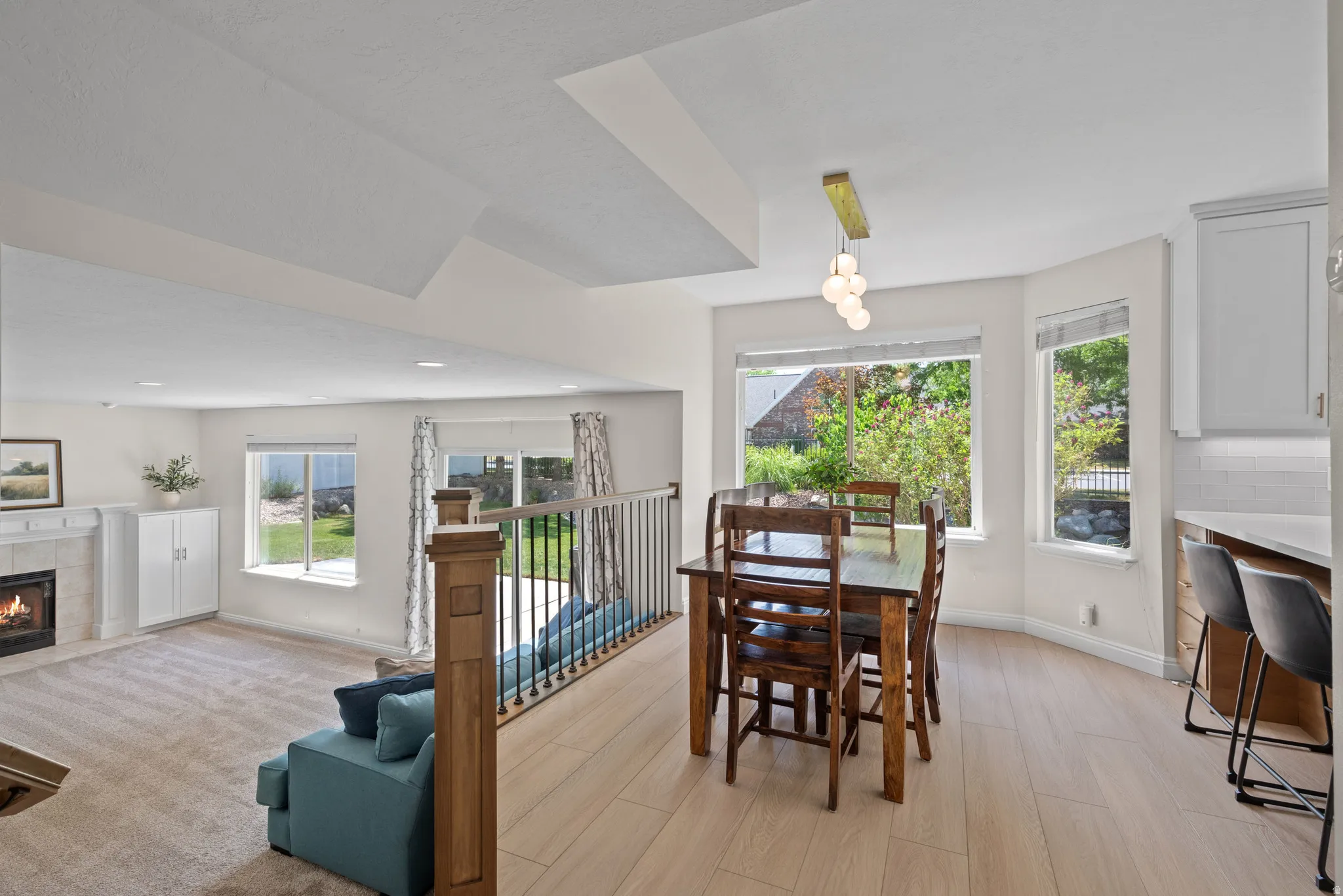 Open-concept living area with a fireplace featuring a tile surround and mantel