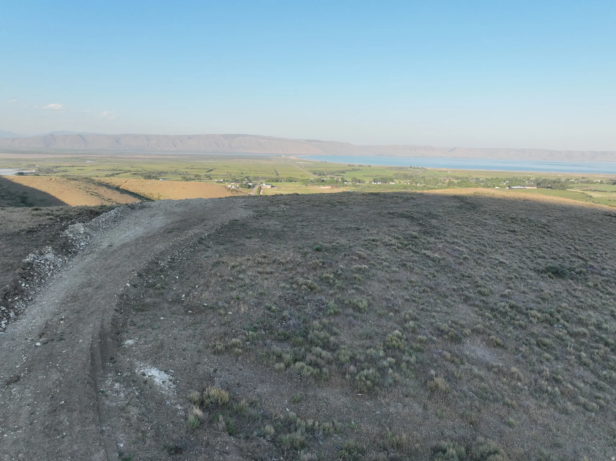 Expansive land parcel featuring natural vegetation and a distant body of water