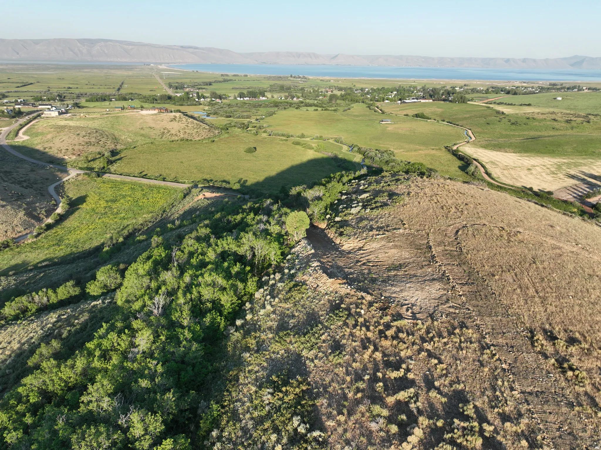 Expansive natural landscape featuring rolling hills and distant water