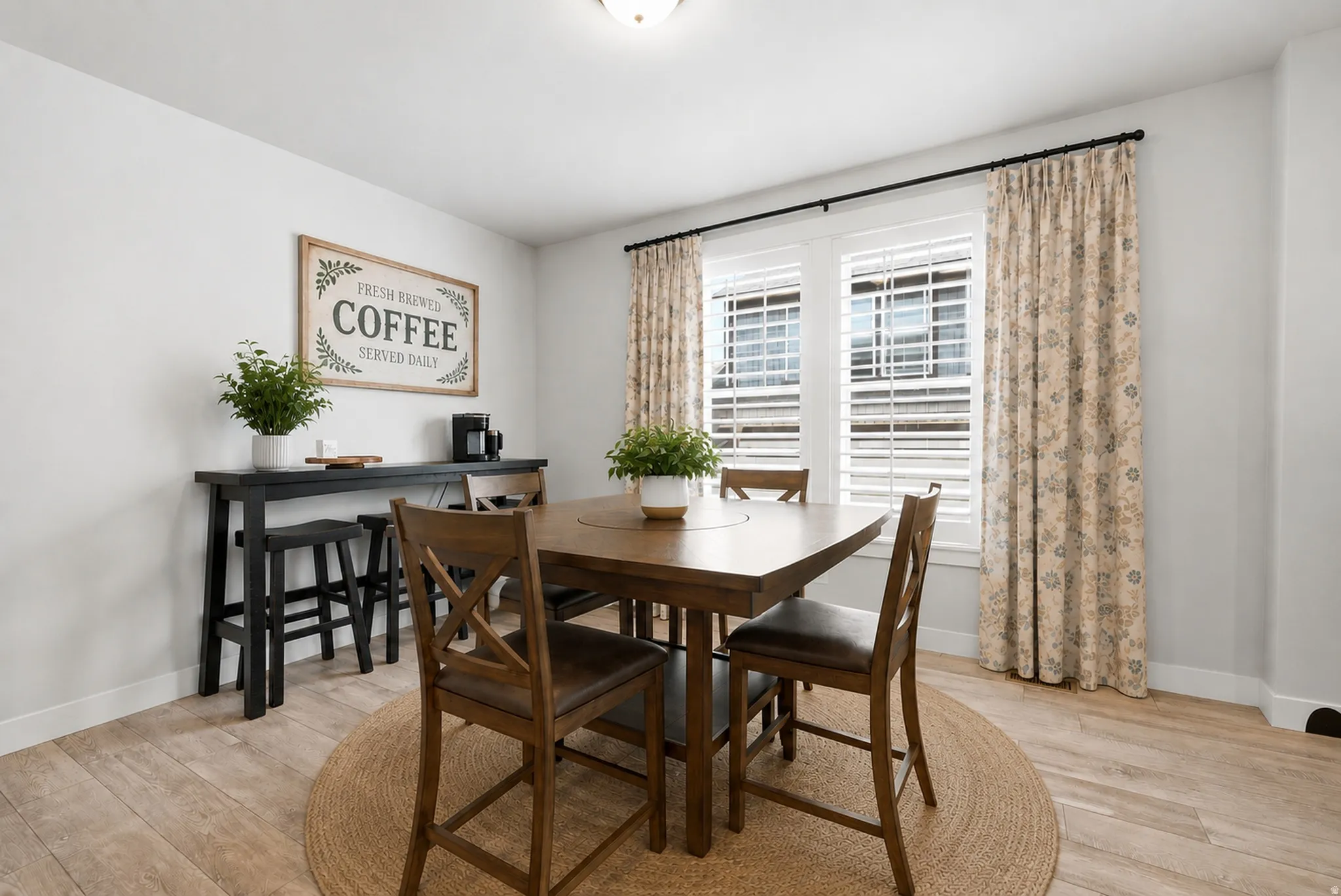 Dining area featuring wood-finish flooring, white baseboards, and light gray wall paint