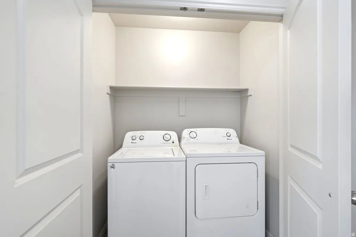 Dedicated laundry closet featuring a top-load washing machine and front-load dryer