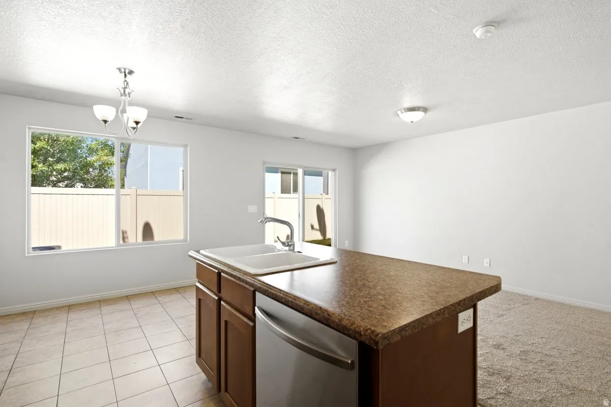 Kitchen island featuring a double basin sink and integrated dishwasher