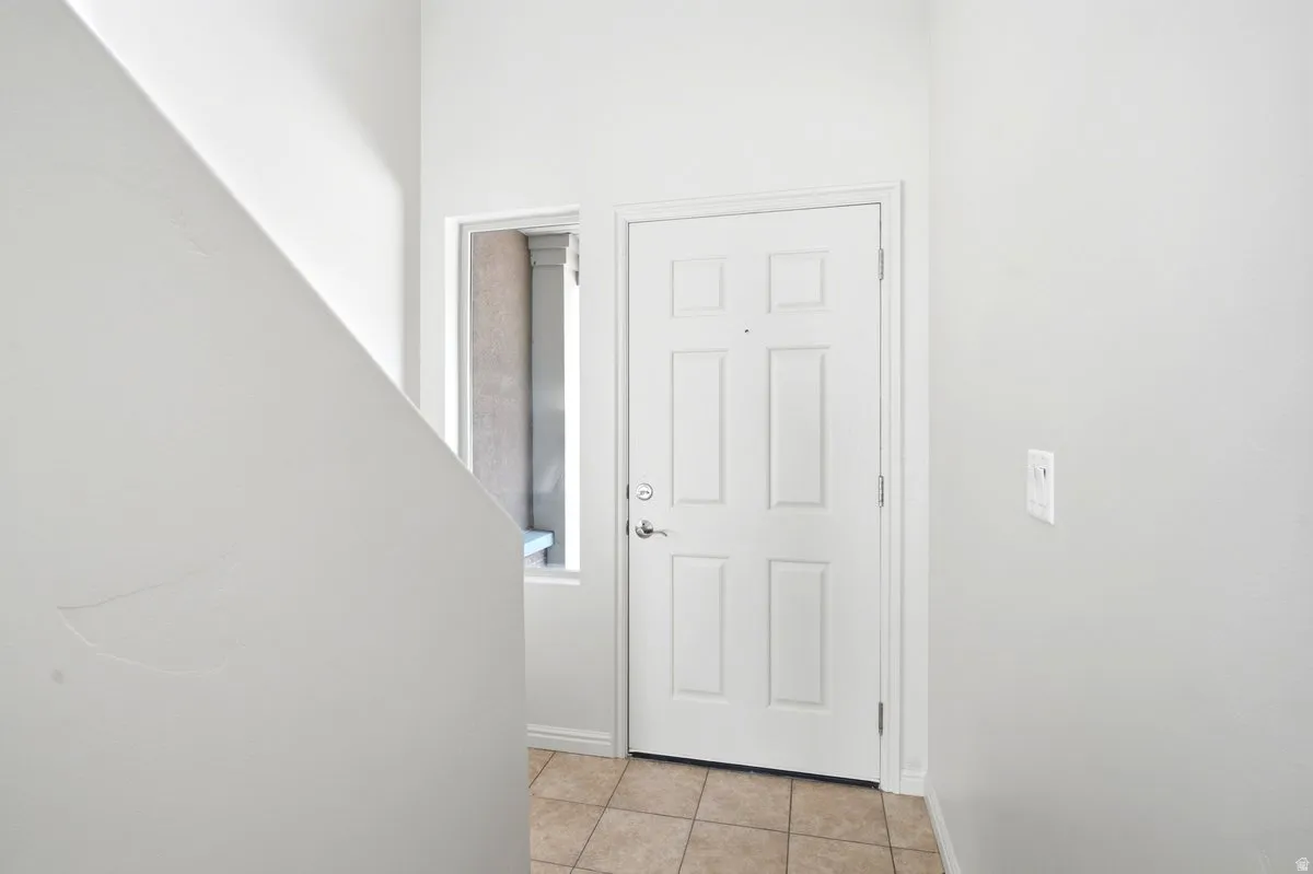 Entryway featuring a paneled door, a sidelight window, and tile flooring