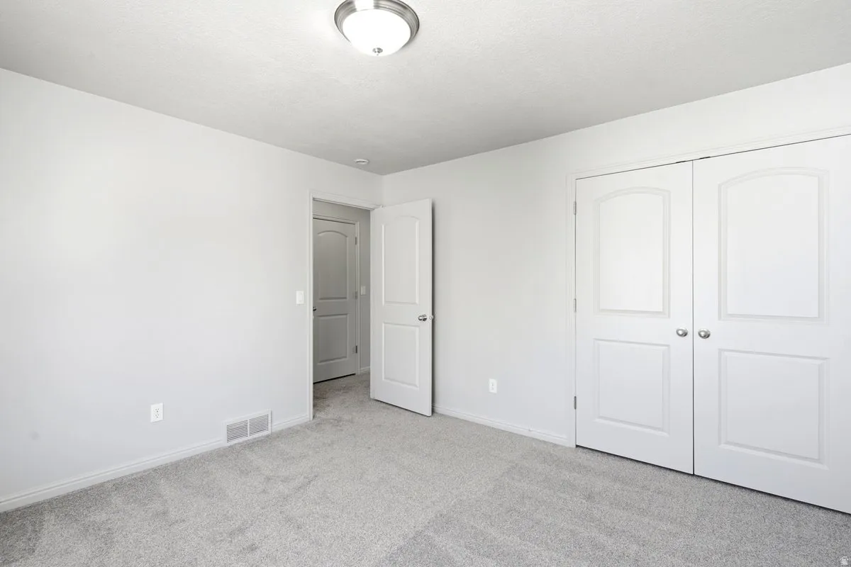 Neutral-toned room featuring light gray walls and a textured ceiling