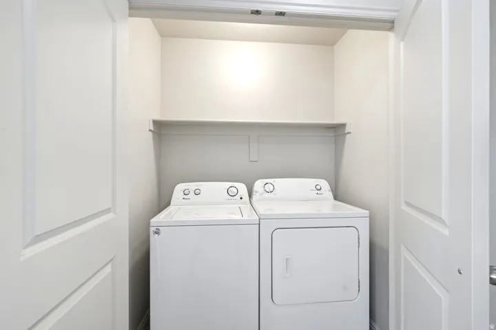 Dedicated laundry closet featuring a top-load washing machine and front-load dryer