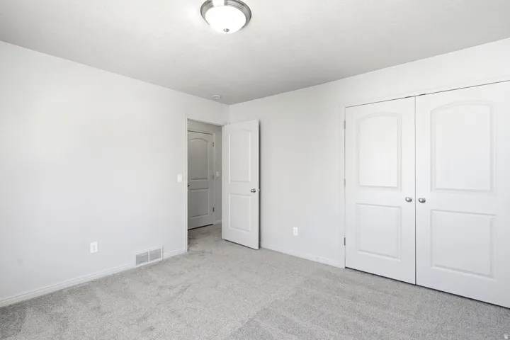 Neutral-toned room featuring light gray walls and a textured ceiling