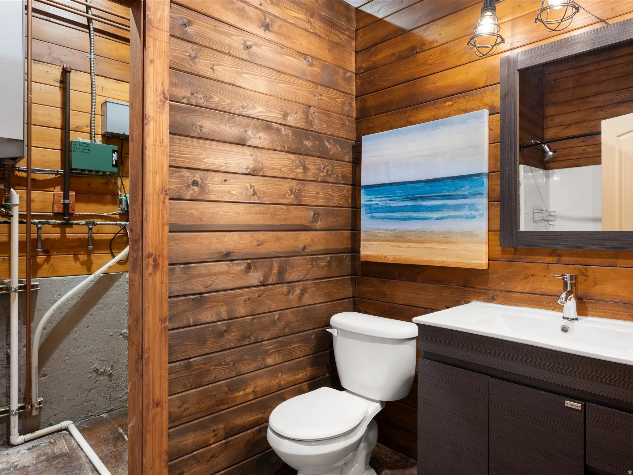 Wood-paneled wall with a dark wood vanity, white integrated sink, and modern faucet