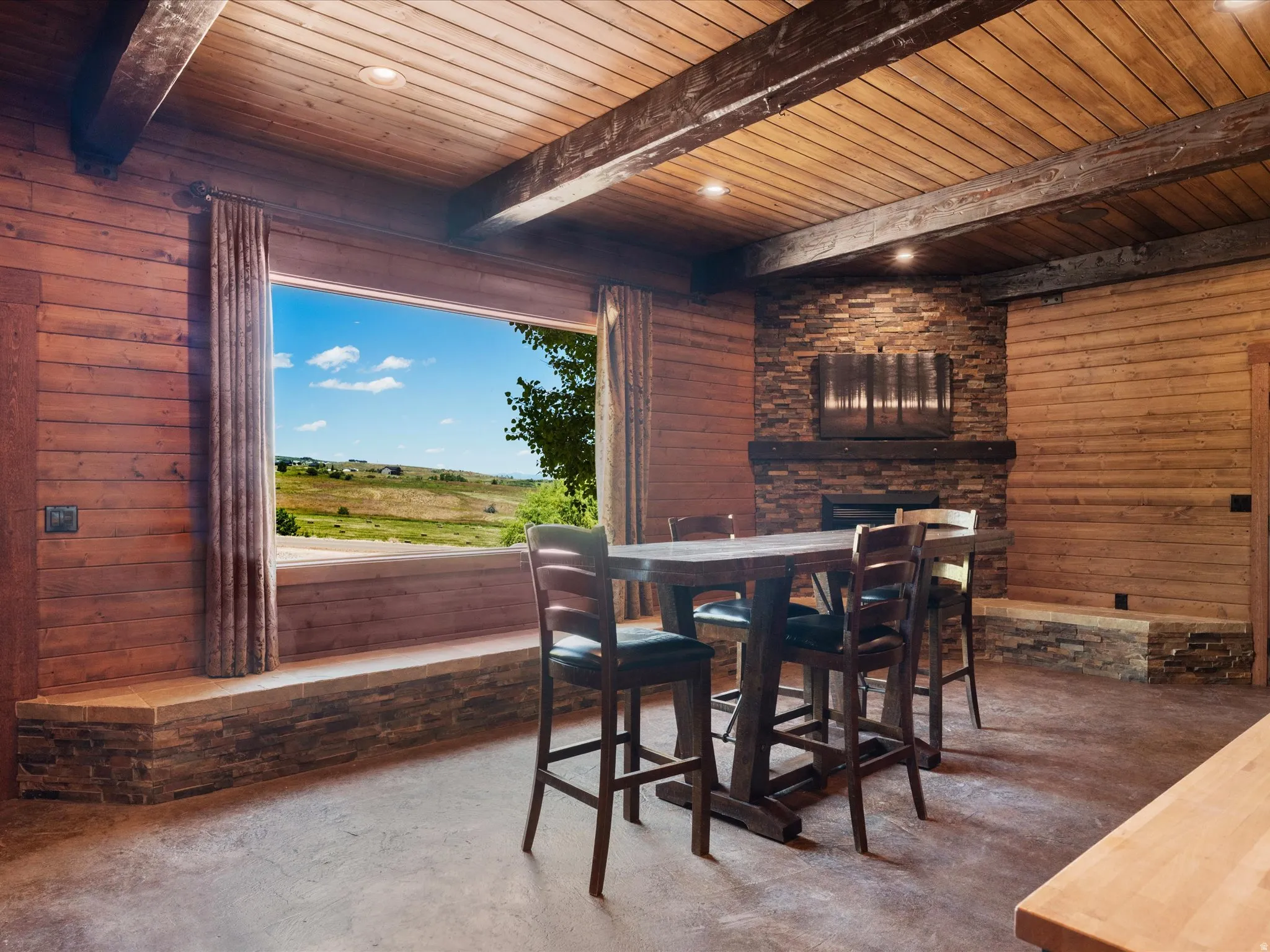 Interior space featuring wood-paneled walls and ceiling, exposed wood beams, and recessed lighting