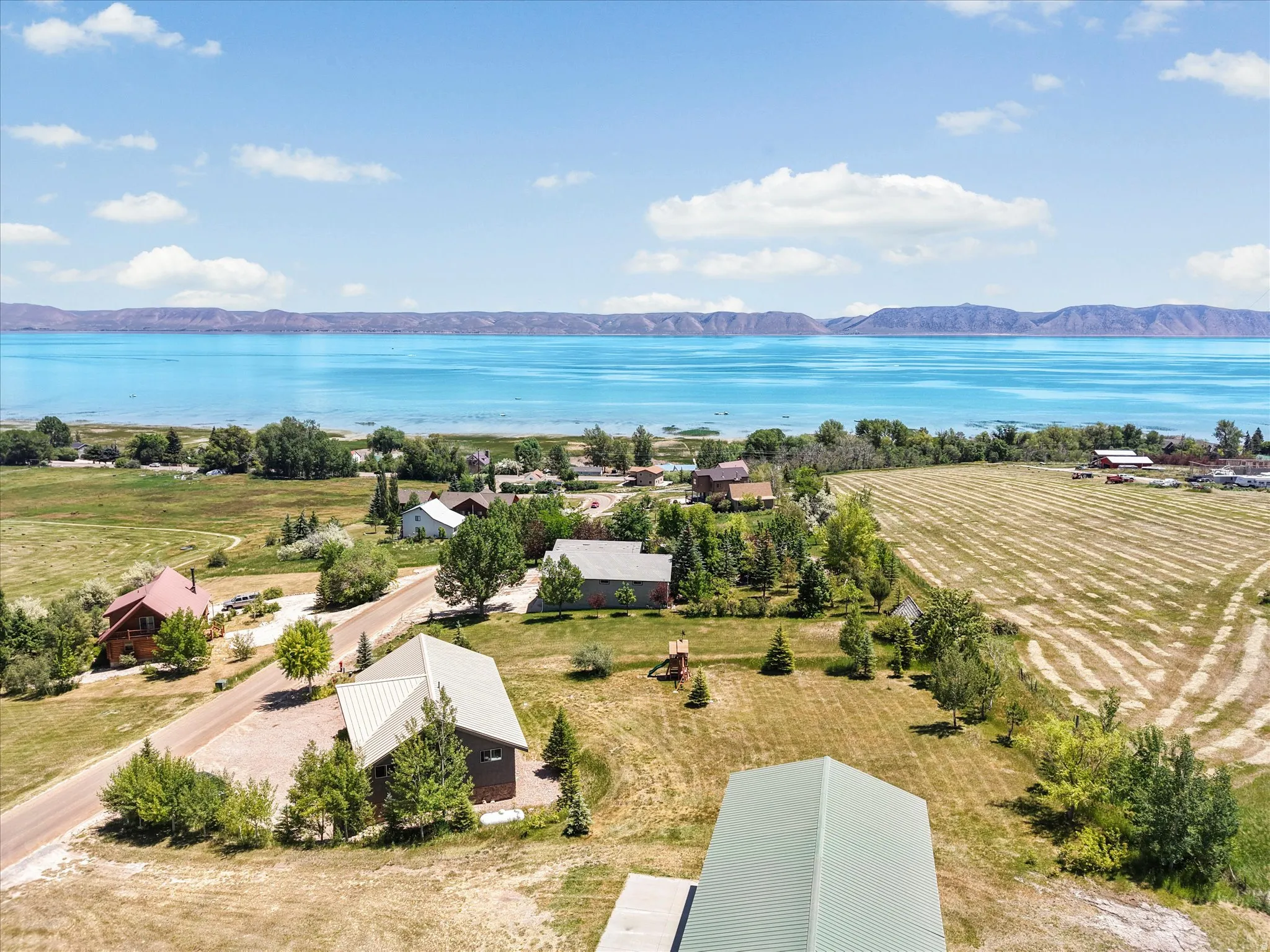 Expansive rural setting featuring a broad body of water, distant mountain range, and scattered residences