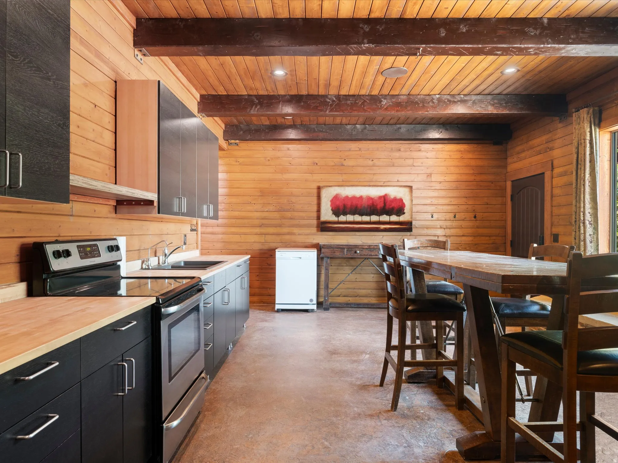 Kitchen area featuring wood-finish walls, exposed wood beams, and recessed lighting