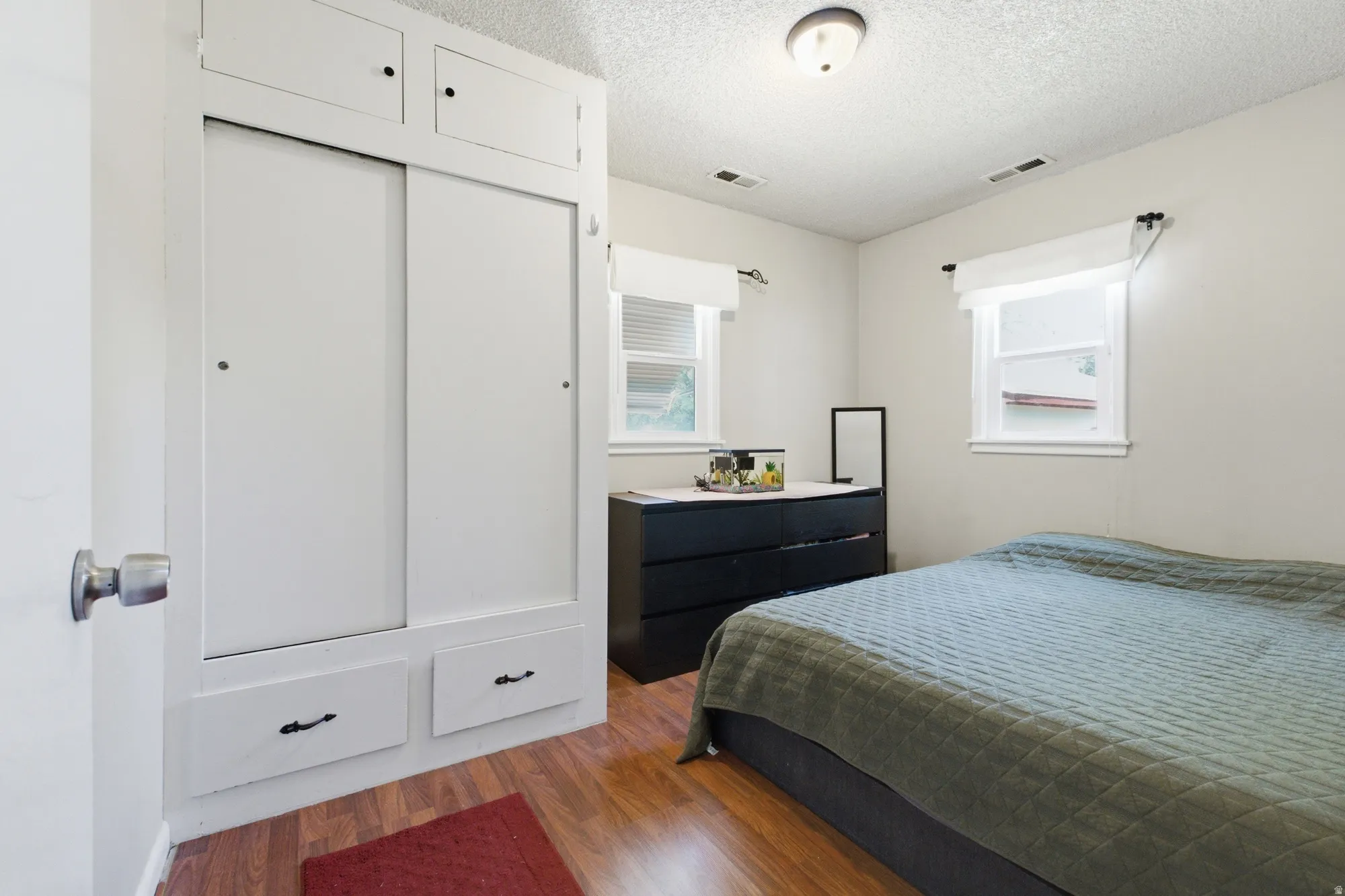 Bedroom with built-in closet storage, two windows, and neutral walls ready for your personal touch.