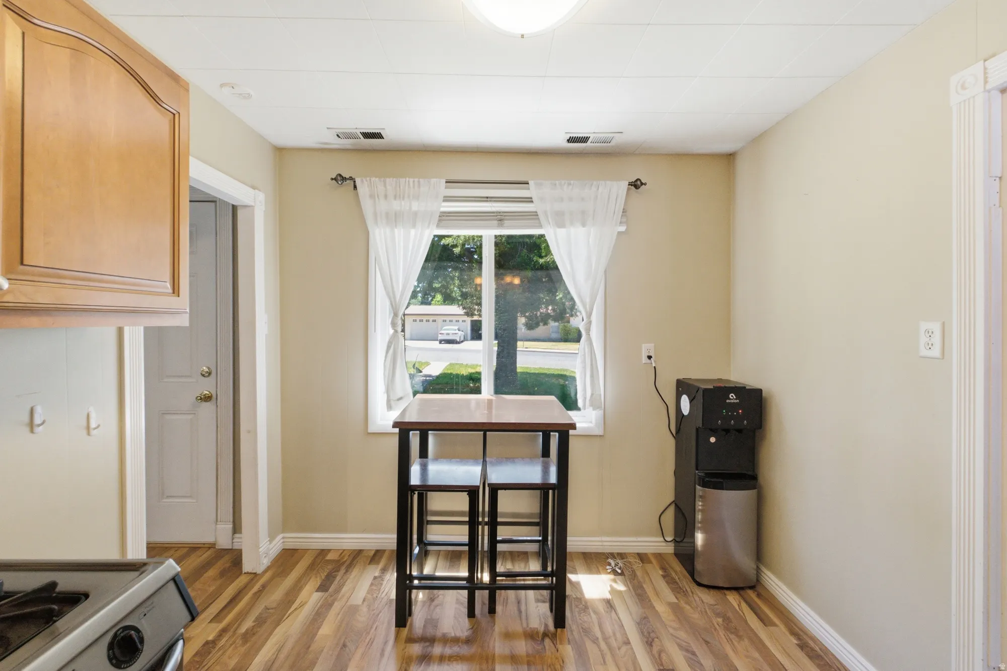 Cozy dining area with front-facing window, warm flooring, and easy flow into the kitchen and living space.